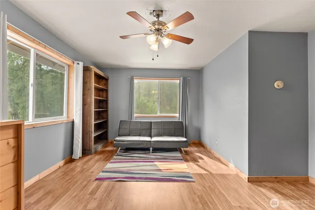 a view of a room with a large window and wooden floor