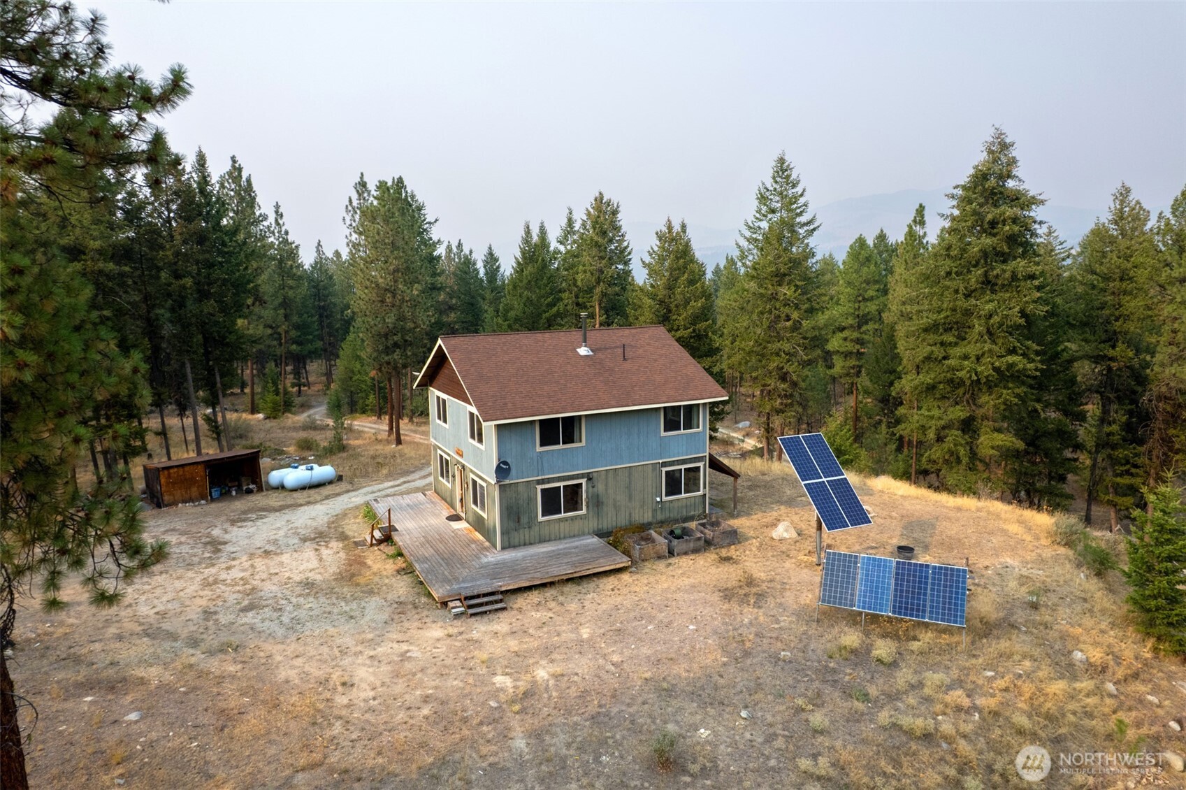 56 Ruby Two Moons Road Tonasket, WA 98855 - Photo 5 of 40 a view of a house with a yard and sitting area