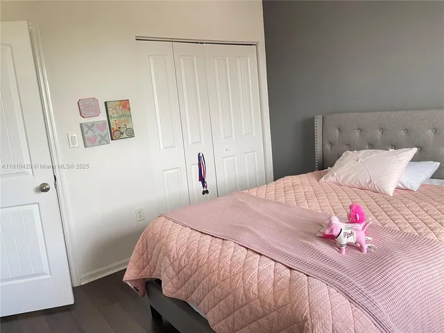 a bedroom with a bed wooden floor and window
