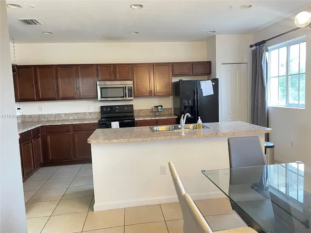 a kitchen with a sink a microwave and cabinets