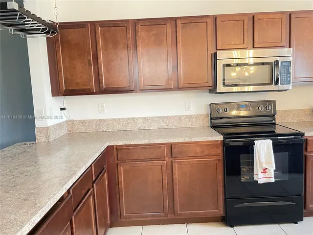 a kitchen with stainless steel appliances granite countertop a stove a microwave and a sink