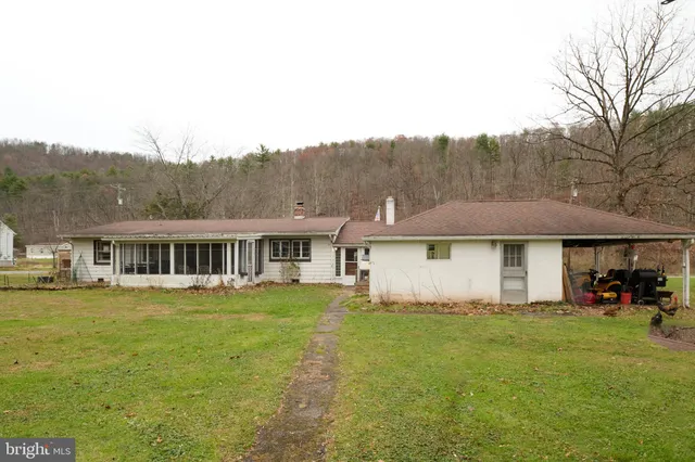 a view of a house with a big yard and large trees