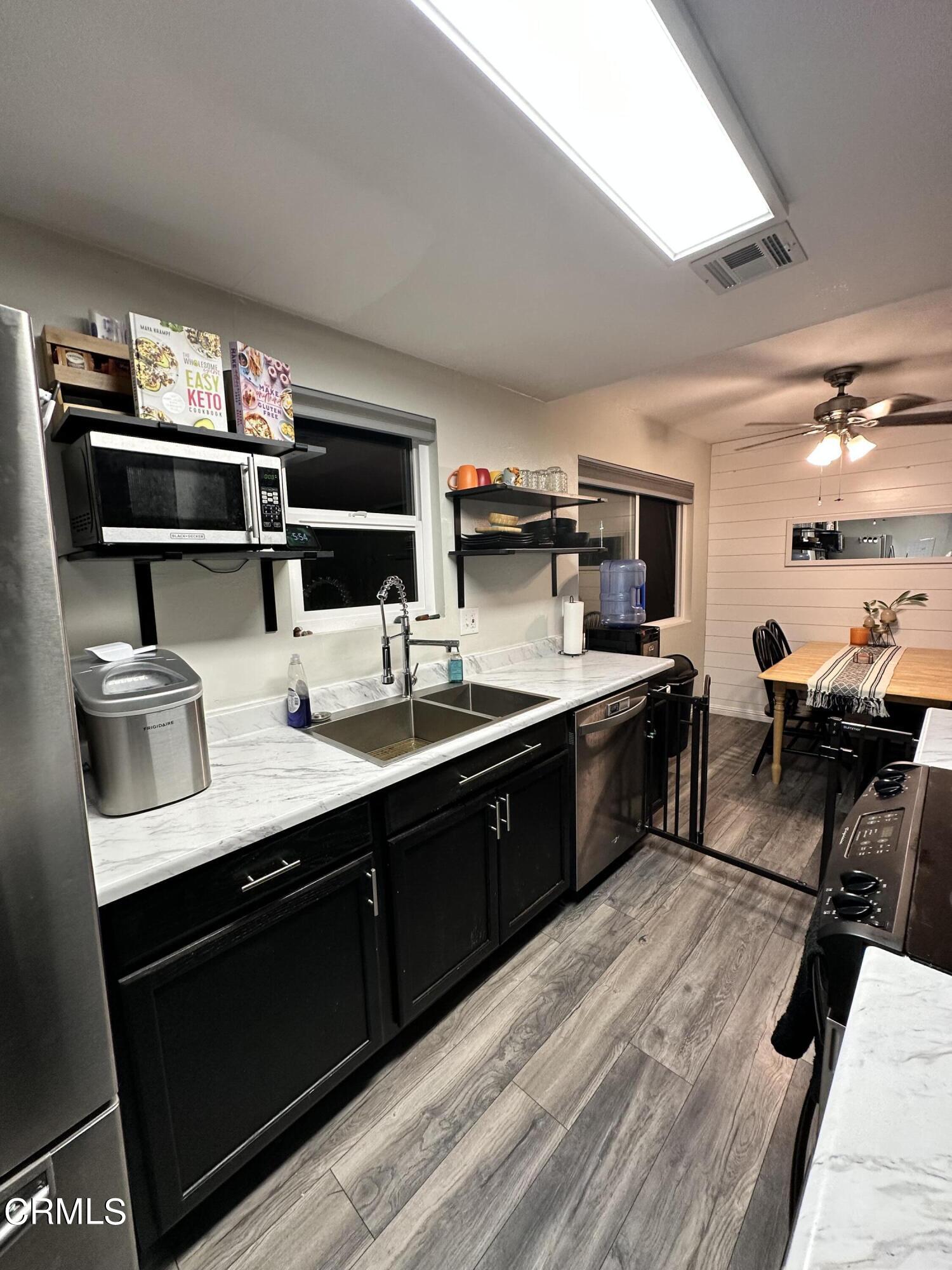 9926 Mission Vega Road, Unit 4 Santee, CA 92071 - Photo 11 of 22 a kitchen with stainless steel appliances kitchen island granite countertop a sink dishwasher stove and oven