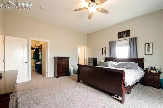 a spacious bedroom with a bed and a chandelier