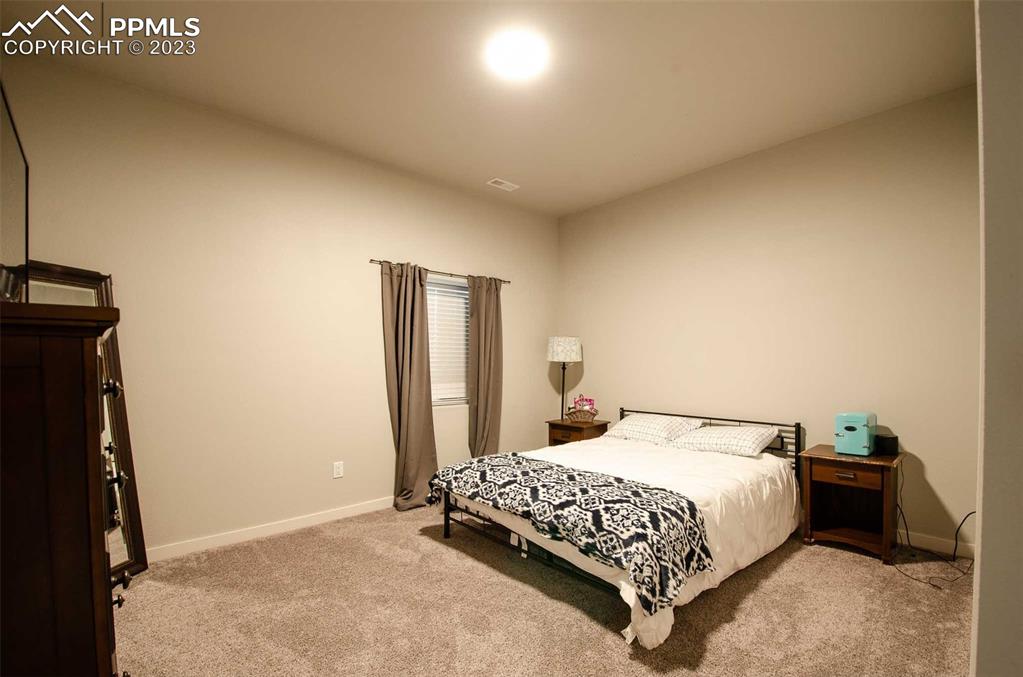 16750 Rabbit Track Trail Colorado Springs, CO 80930 - Photo 31 of 50 a bedroom with a bed and a night stand