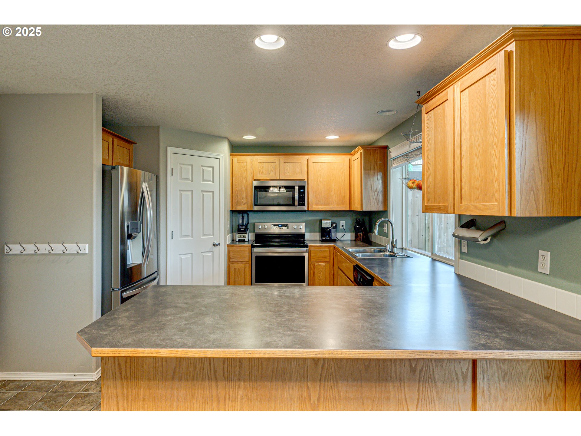 1825 North 9th Way Ridgefield, WA 98642 - Photo 4 of 30 a view of a kitchen counter top space a sink wooden floor and a window