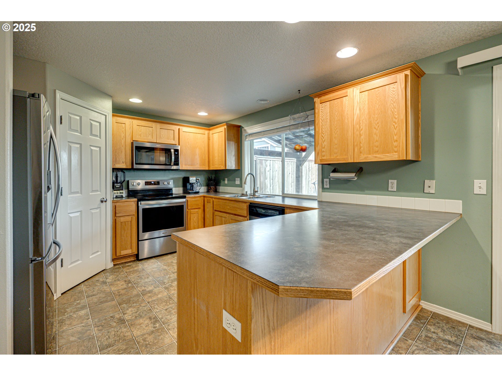 1825 North 9th Way Ridgefield, WA 98642 - Photo 5 of 30 a kitchen with stainless steel appliances granite countertop a sink a stove top oven a counter space and cabinets