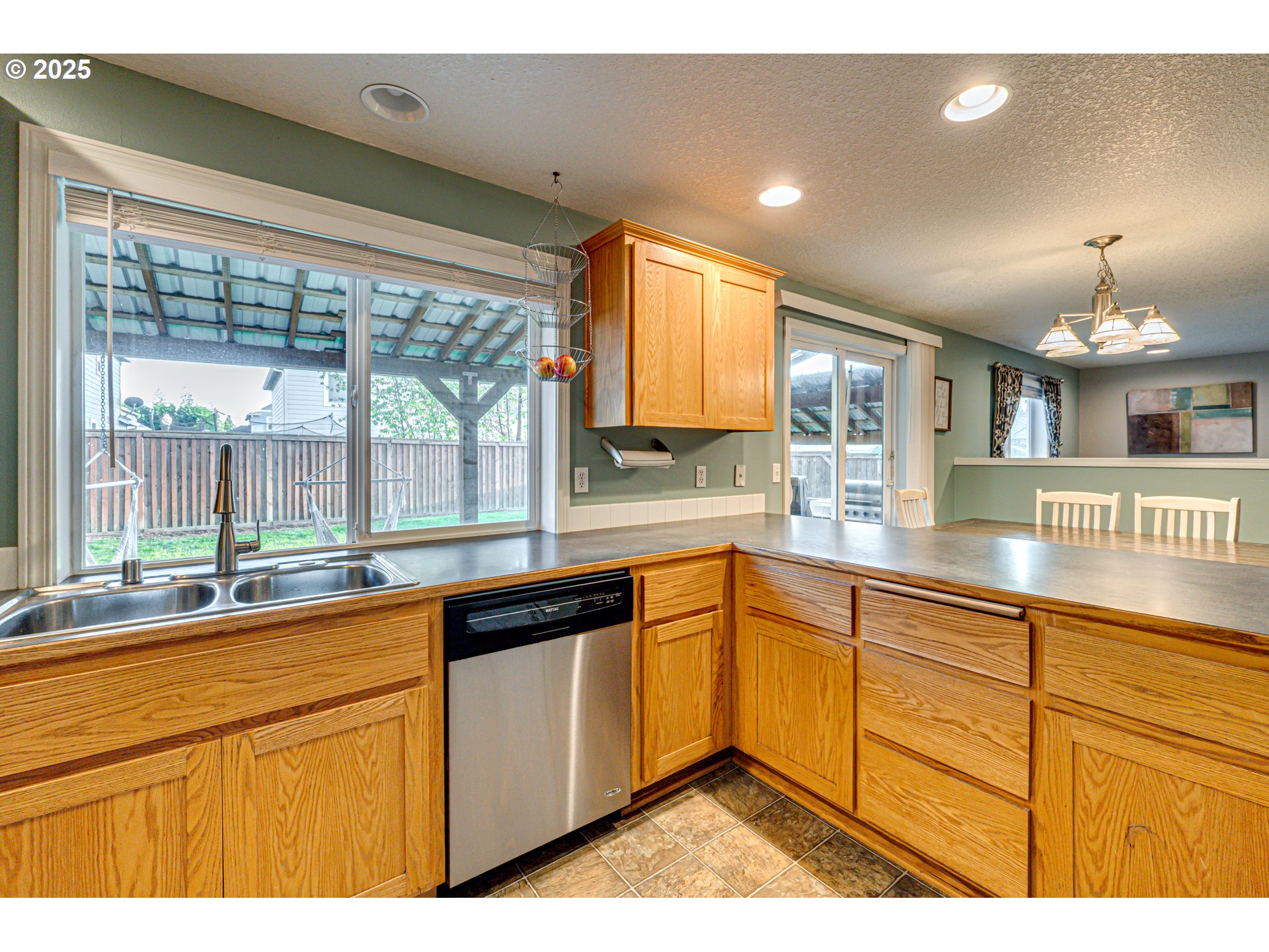 1825 North 9th Way Ridgefield, WA 98642 - Photo 7 of 30 a large kitchen with kitchen island a large window cabinets and stainless steel appliances