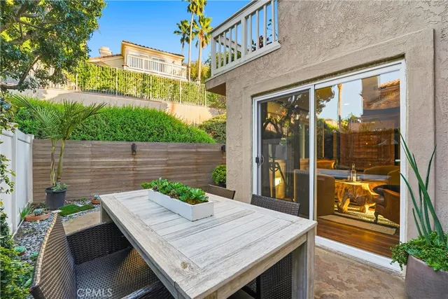 a view of a patio with table and chairs potted plants with wooden floor and fence