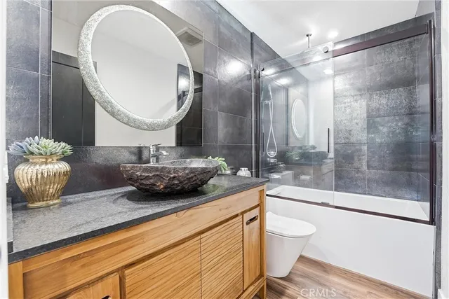a bathroom with a granite countertop sink mirror toilet and bathtub