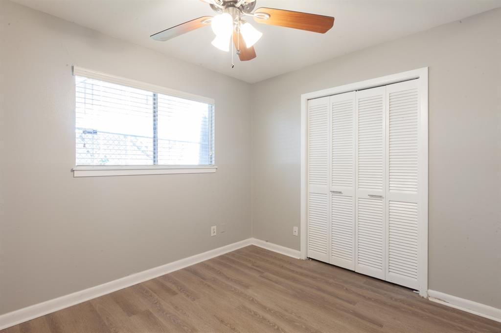 3407 Grooms Street Austin, TX 78705 - Photo 6 of 10 an empty room with wooden floor chandelier fan and windows