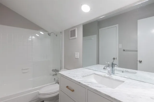 a bathroom with a granite countertop sink toilet and shower