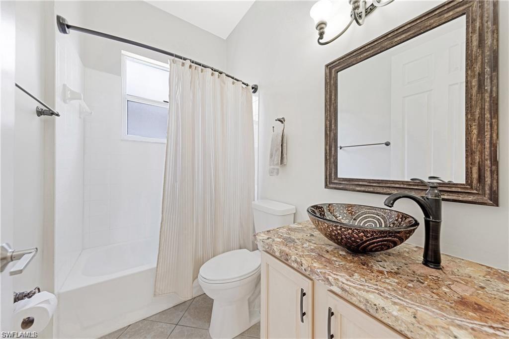 349 Harvard Lane Naples, FL 34104 - Photo 16 of 31 a bathroom with a granite countertop sink a toilet and shower
