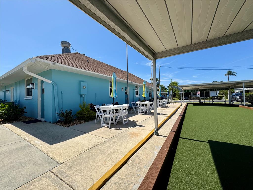 3301 Alt 19, Unit 404 Dunedin, FL 34698 - Photo 43 of 67 a view of a patio with a table and chairs under an umbrella