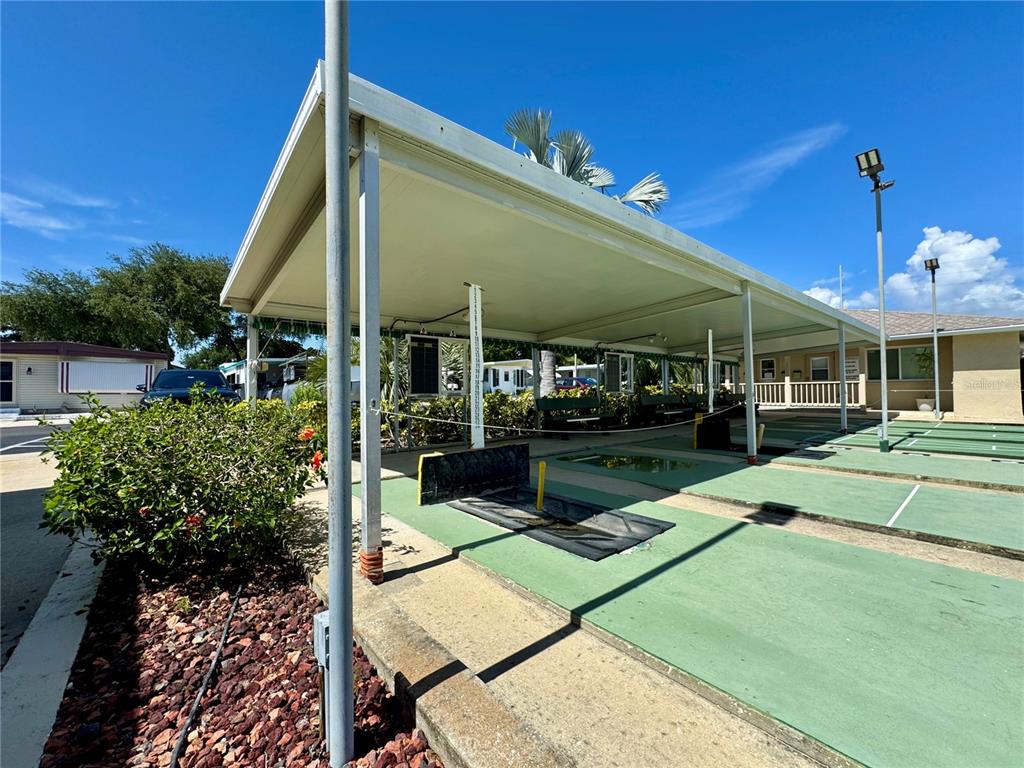 3301 Alt 19, Unit 404 Dunedin, FL 34698 - Photo 44 of 67 a view of a patio with table and chairs potted plants with wooden floor and fence