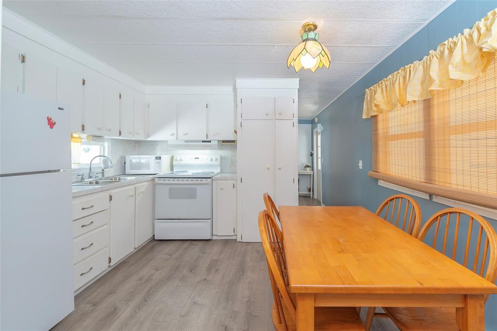 3301 Alt 19, Unit 404 Dunedin, FL 34698 - Photo 8 of 67 a kitchen with a table chairs appliances and cabinets