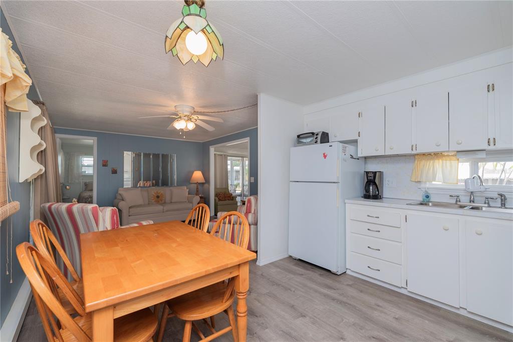 3301 Alt 19, Unit 404 Dunedin, FL 34698 - Photo 9 of 67 a kitchen with stainless steel appliances granite countertop a dining table chairs sink and cabinets
