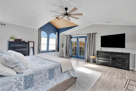 a bedroom with a bed and a flat screen tv