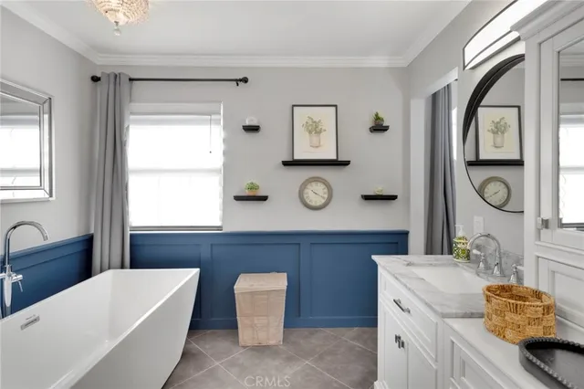 a bathroom with a tub a sink and a large mirror