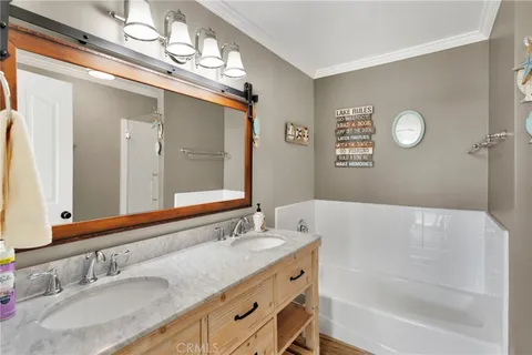 a bathroom with a granite countertop sink mirror and a bathtub