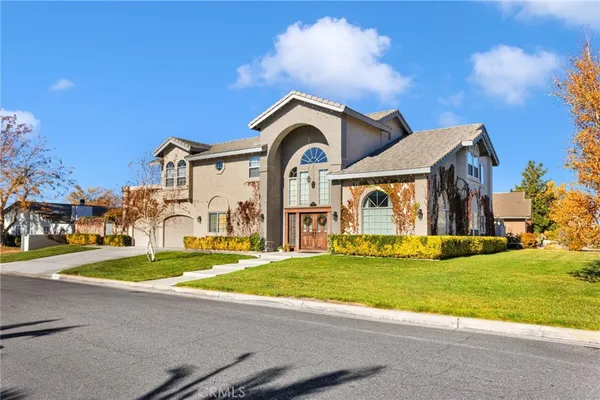 a front view of a house with a garden and yard