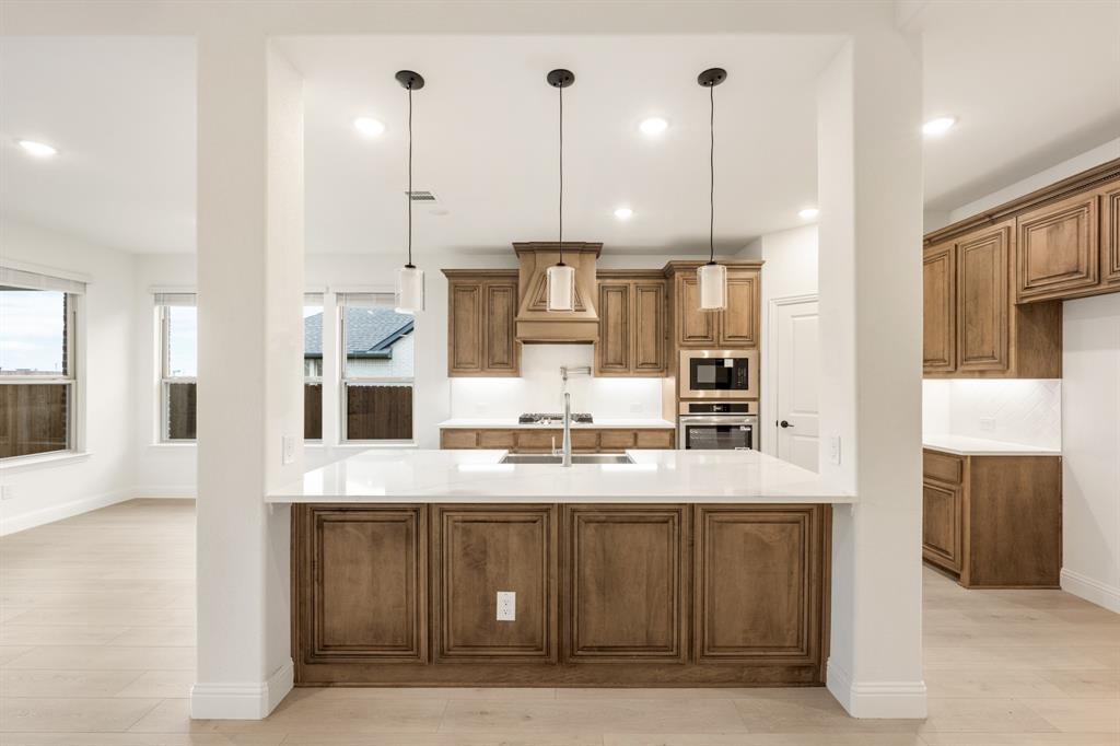 2813 Spg Vly Way Anna, TX 75409 - Photo 12 of 40 a large kitchen with kitchen island a large counter top stainless steel appliances and cabinets