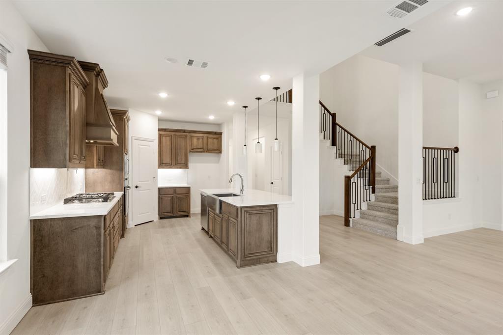2813 Spg Vly Way Anna, TX 75409 - Photo 16 of 40 a view of a kitchen with kitchen island wooden floor center island stainless steel appliances wooden floor and living room view