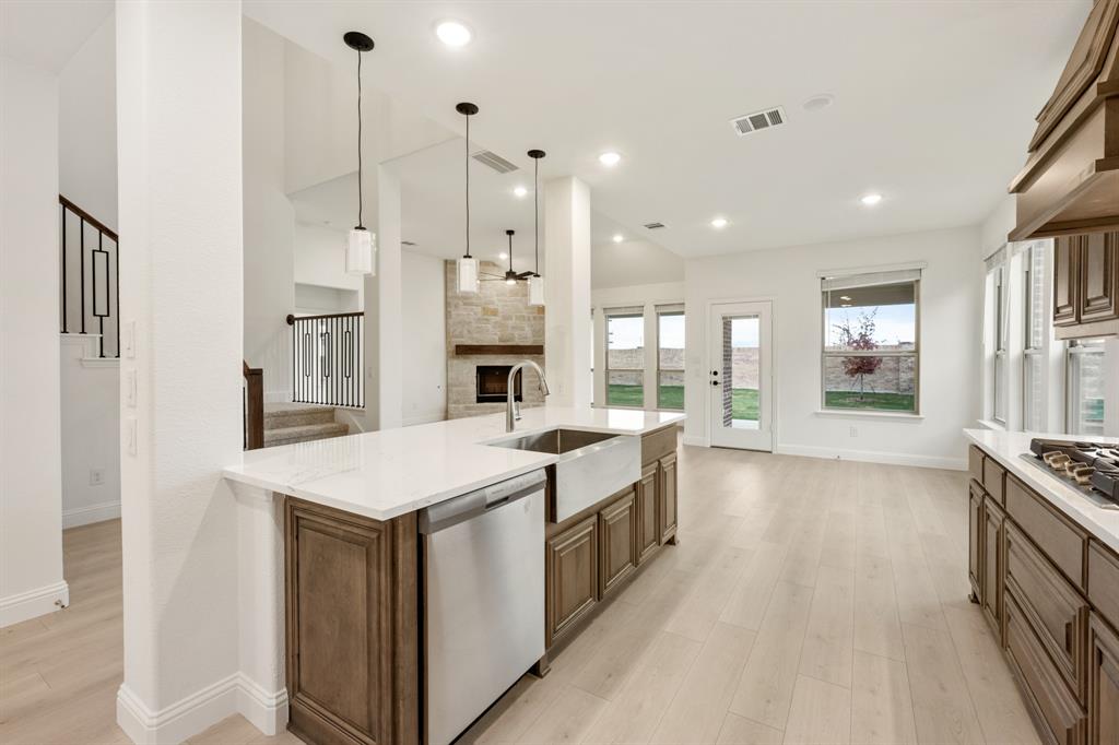 2813 Spg Vly Way Anna, TX 75409 - Photo 17 of 40 a large kitchen with stainless steel appliances kitchen island a large counter top and a wooden floors