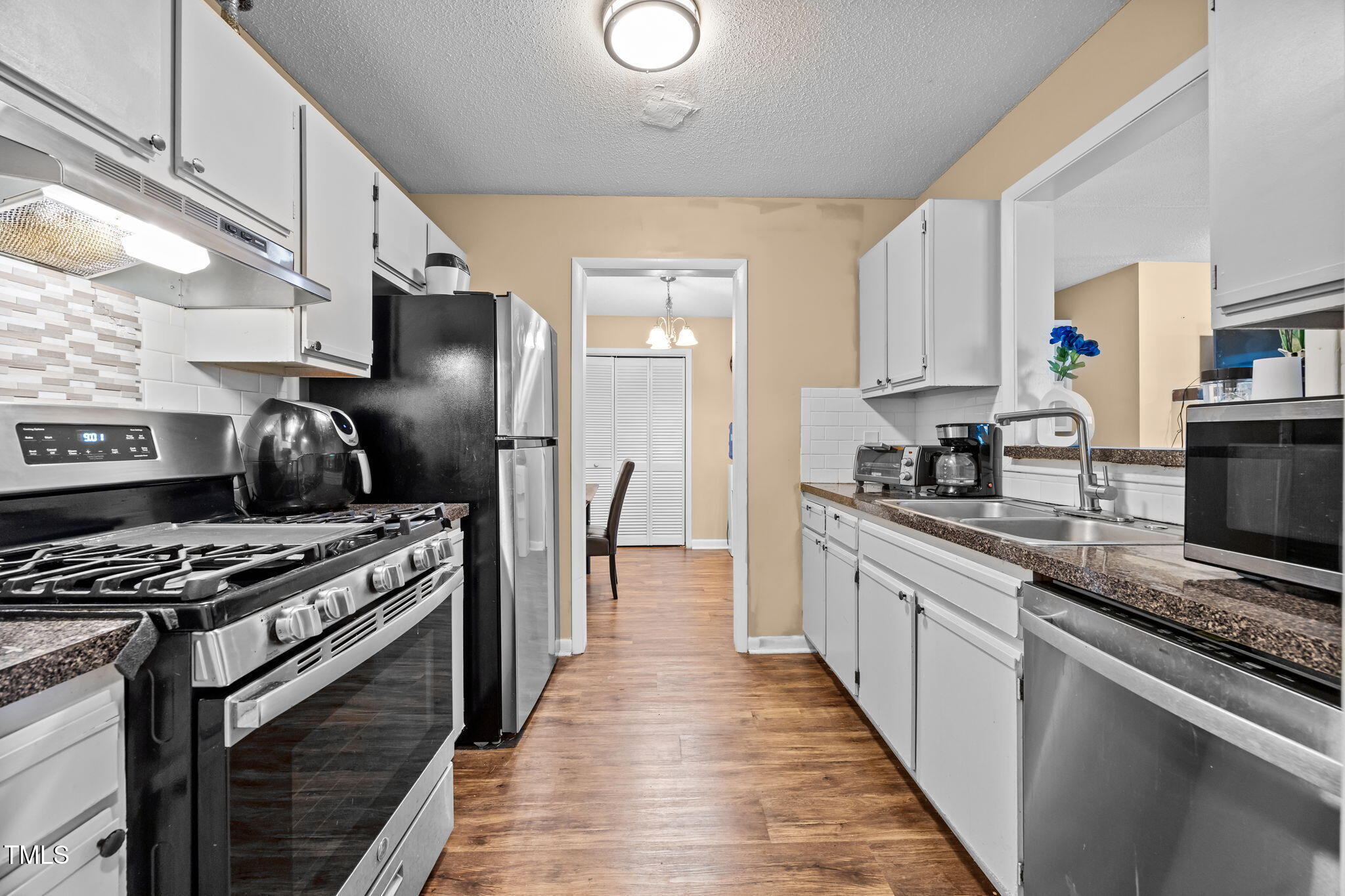 5816 Pointer Drive, Unit 102 Raleigh, NC 27609 - Photo 12 of 25 a kitchen with stainless steel appliances granite countertop a stove a sink and a refrigerator