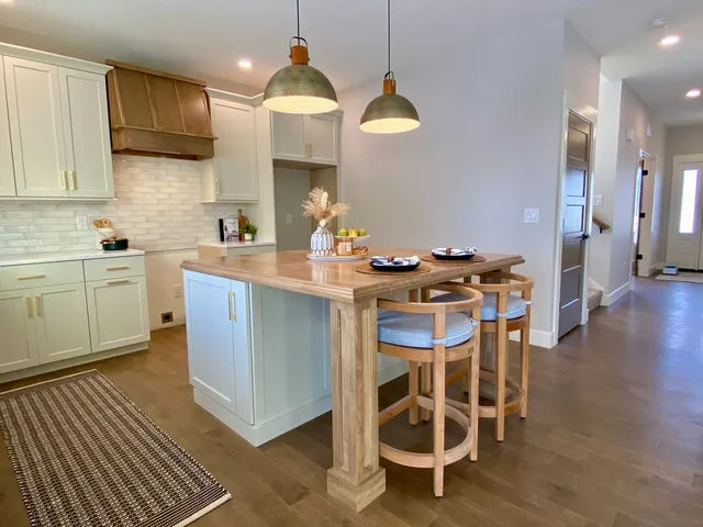 a kitchen with stainless steel appliances a stove a sink cabinets and a dining table