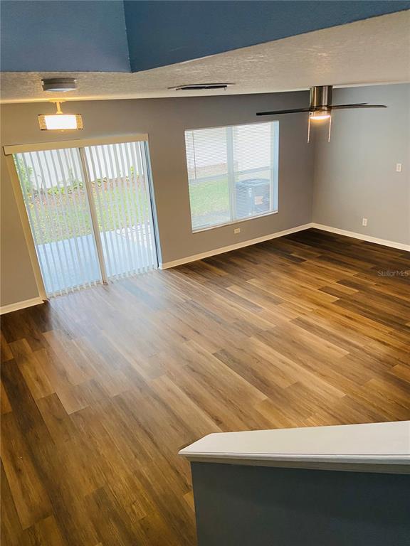 11658 Mango Ridge Boulevard Seffner, FL 33584 - Photo 3 of 20 a view of an empty room with wooden floor and a window