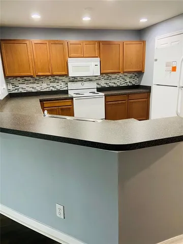 a kitchen with granite countertop wooden cabinets and a stove