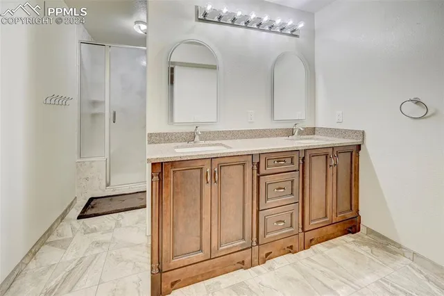 a spacious bathroom with a granite countertop sink a mirror and a vanity