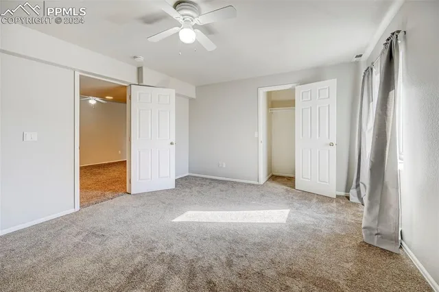 an empty room with fan and entrance