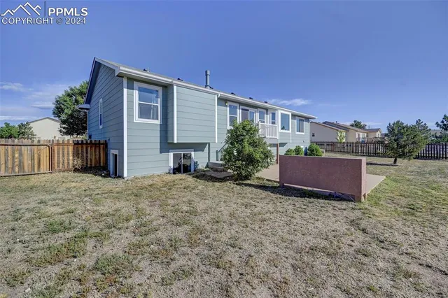 a front view of house with yard and trees in the background