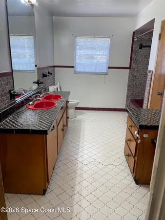 a bedroom with a bed and a flat tv screen on dresser