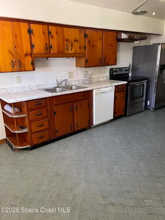 a kitchen with stainless steel appliances kitchen island granite countertop a table chairs in it and wooden floors