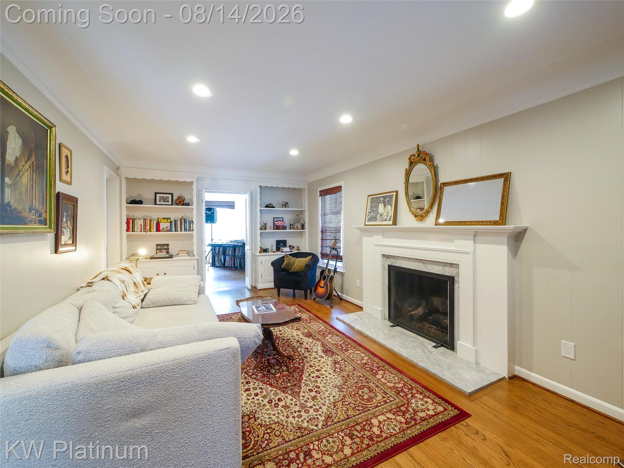 657 Hawthorne Road Grosse Pointe, MI 48236 - Photo 4 of 28 Recessed lighting, wood flooring, built-in shelving, white fireplace with hearth, and an open doorway