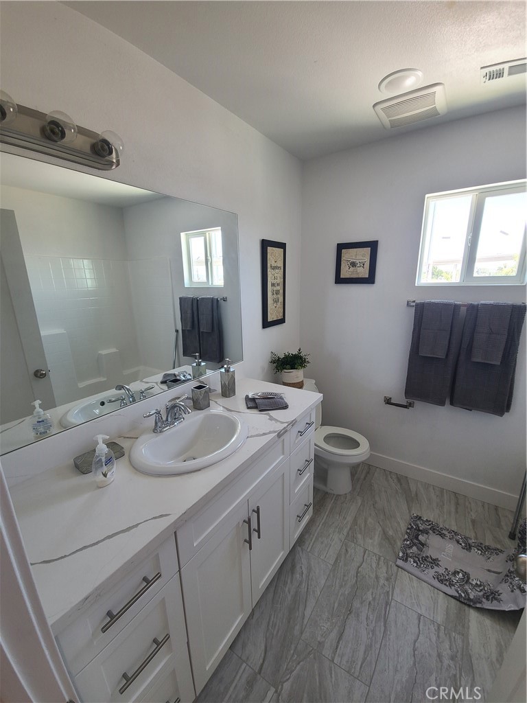 12766 Torch Street, Unit B Baldwin Park, CA 91706 - Photo 11 of 13 a bathroom with a double vanity sink toilet and a mirror