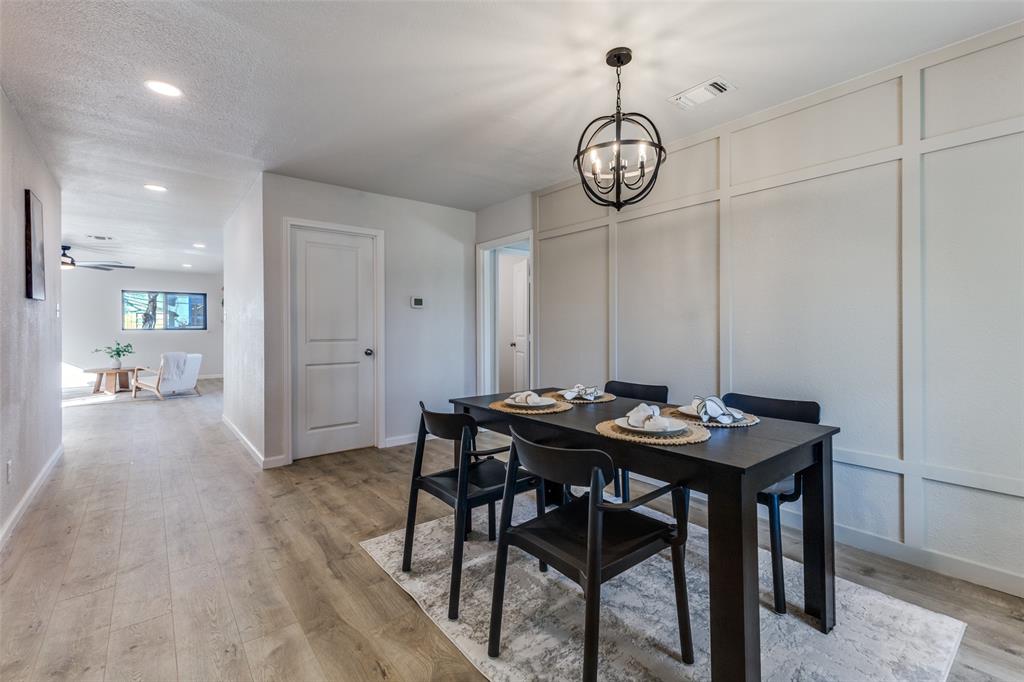 3719 Dutton Drive Dallas, TX 75211 - Photo 5 of 24 a view of a dining room with furniture wooden floor and a chandelier