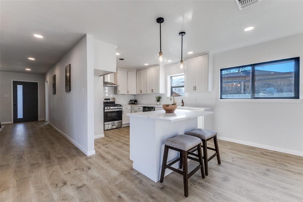 3719 Dutton Drive Dallas, TX 75211 - Photo 8 of 24 a kitchen with a table chairs refrigerator and microwave