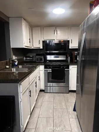 a kitchen with stainless steel appliances granite countertop a stove a refrigerator and a oven