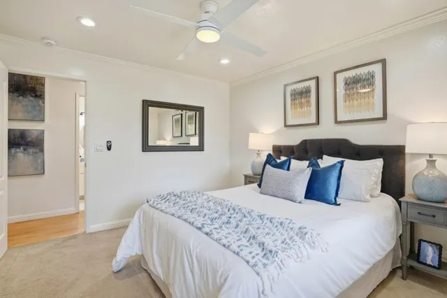 a bedroom with a large bed and a painting on the wall