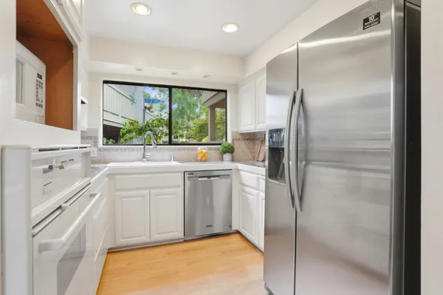 a kitchen with a refrigerator a sink and a window