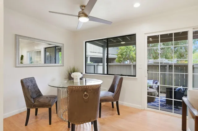 a dining room with furniture a floor to ceiling window and wooden floor