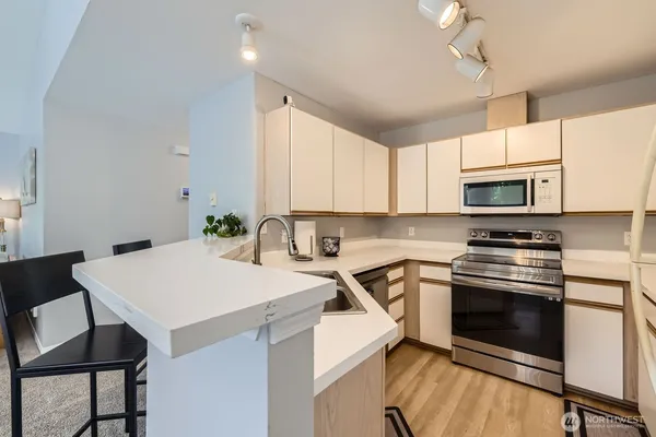 a kitchen with a stove a sink and a microwave