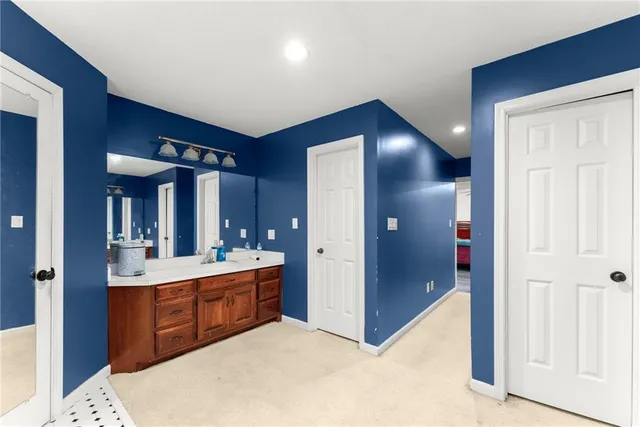 a bathroom with a granite countertop toilet sink and mirror