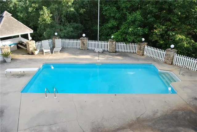 a kitchen with stainless steel appliances kitchen island granite countertop a refrigerator a sink dishwasher a stove and a dining table with wooden floor