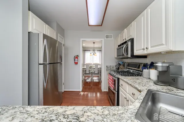 a kitchen with stainless steel appliances granite countertop a refrigerator sink and stove
