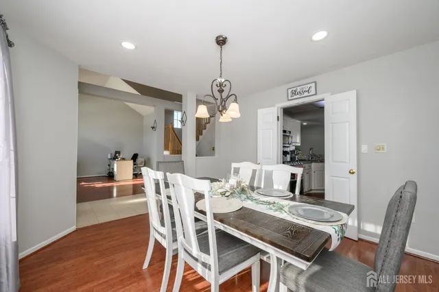 a dining room with furniture a chandelier and wooden floor